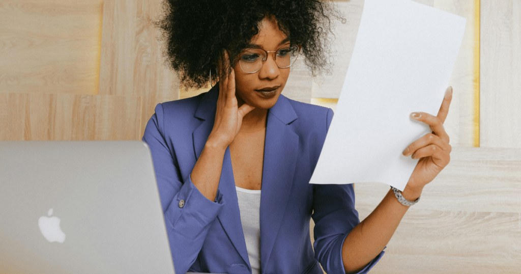 Investing with ETFs: A woman stares at a document with a look of confusion on her face. 