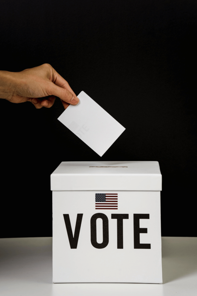 A man inserts his ballot into a voting box.